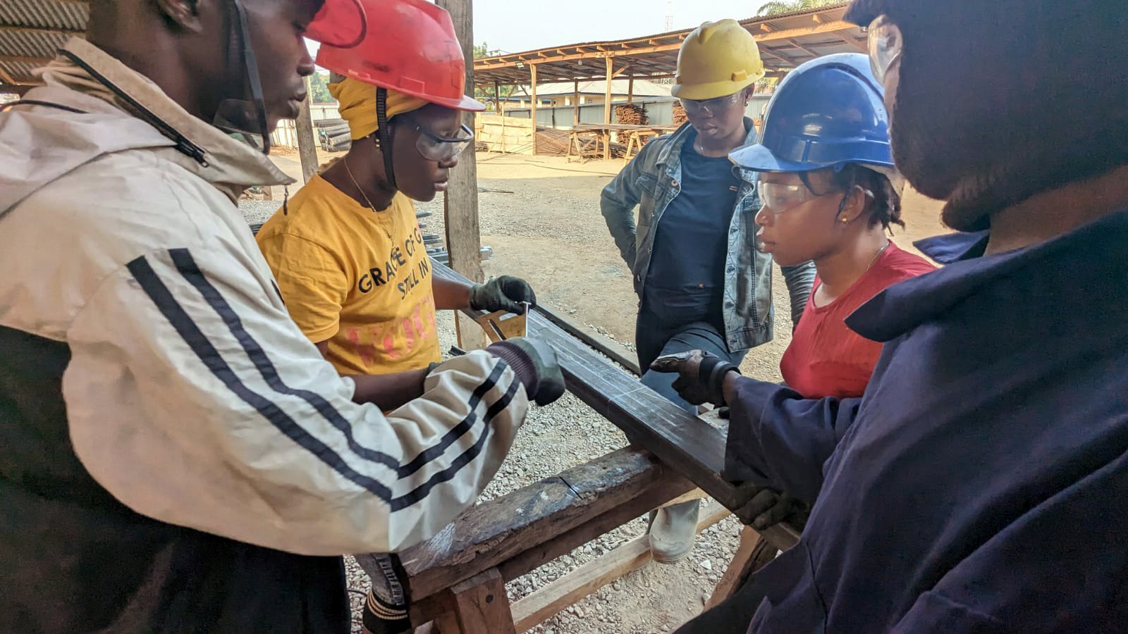 A group of five workers wearing protective gear at a construction site. 