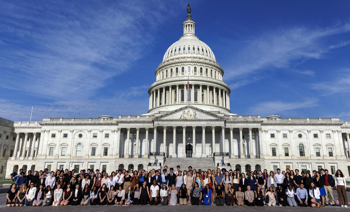 A large group of PIHers stand and kneel outside the Capitol Building in Washington D.C.